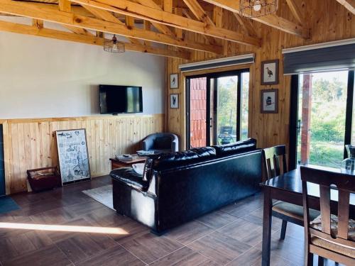 uma sala de estar com um sofá e uma mesa em Rio Blanco em Hornopiren