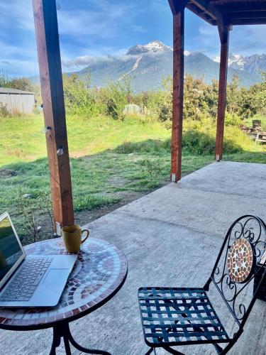 a table and chair with a laptop on a patio at Rio Blanco in Hornopiren