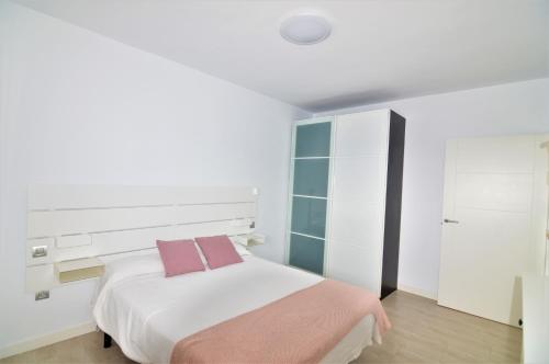 ein weißes Schlafzimmer mit einem Bett und einem Schrank in der Unterkunft Apartamento Martina in Puerto del Carmen