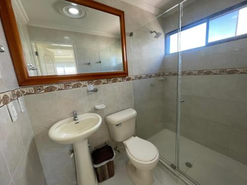 a bathroom with a toilet and a sink and a mirror at Vista Al Mar, Aire Acondicionado en Todo el Apto, Wi-Fi, Parqueadero in Cartagena de Indias