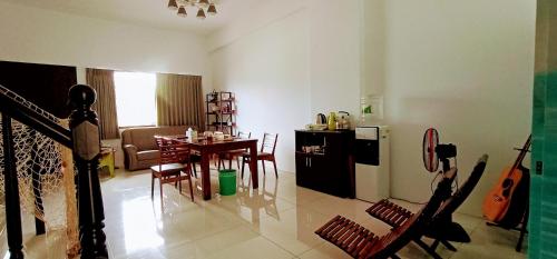 a living room with a kitchen and a table with chairs at Yu Hai B&B in Jiaoxi