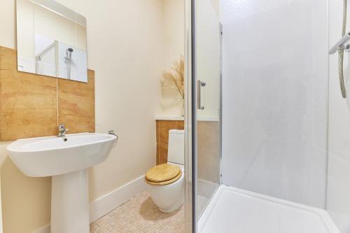 a bathroom with a sink and a toilet and a shower at A *Spacious* 3 Bedroom Flat - Town Centre Berwick Upon Tweed in Berwick-Upon-Tweed