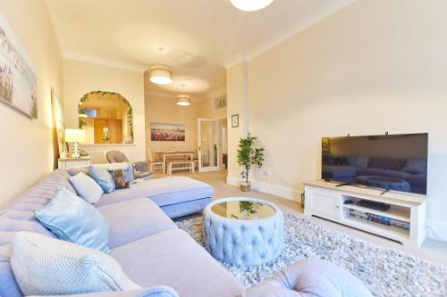 a living room with a couch and a tv at A *Spacious* 3 Bedroom Flat - Town Centre Berwick Upon Tweed in Berwick-Upon-Tweed