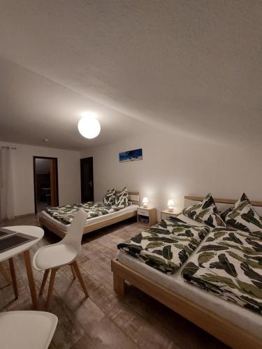 um quarto com duas camas e uma mesa e cadeiras em FeWo2&Bad Wurzach em Bad Wurzach