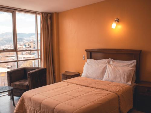 una camera d'albergo con un letto e una grande finestra di Marzano a Cajamarca