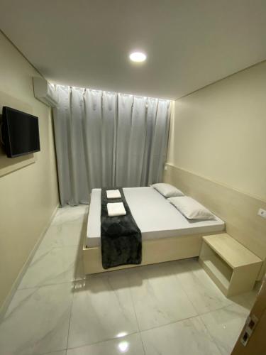 a bedroom with a bed and a television in it at Hotel Flex Tatuapé in Sao Paulo
