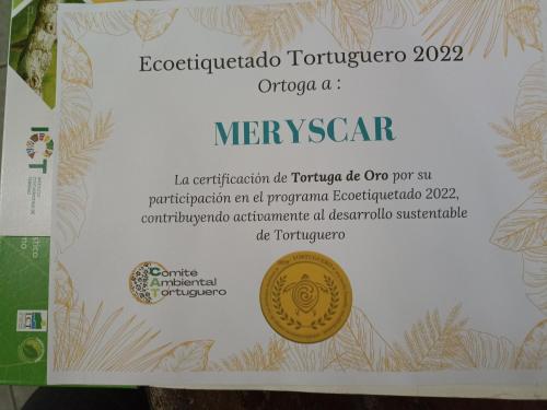 a sign for a moroccan cryptocourse with a coin on it at Hospedaje Meryscar in Tortuguero