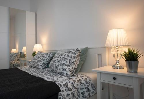 - une chambre avec un lit et une table avec une lampe dans l'établissement Luxus Apartament Fitness&Spa z sauną i siłownią, à Gdańsk
