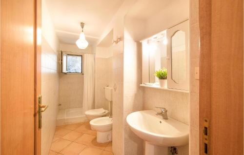 een witte badkamer met een wastafel en een toilet bij Beautiful Home In Cetraro With Kitchen in Cetraro