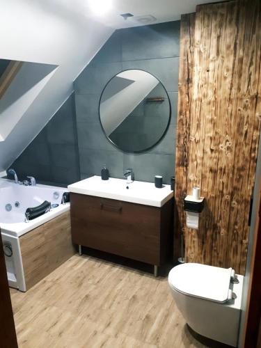 a bathroom with a sink and a toilet and a mirror at Browarna 14 jacuzzi, prestige in Racibórz
