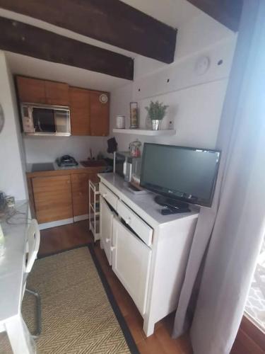 une cuisine avec une télévision à écran plat sur un comptoir dans l'établissement Duplex cocooning avec vue lac et montagnes, à Savines