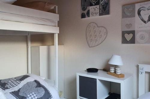 1 dormitorio con litera y TV en un escritorio en Duplex cocooning avec vue lac et montagnes en Savines