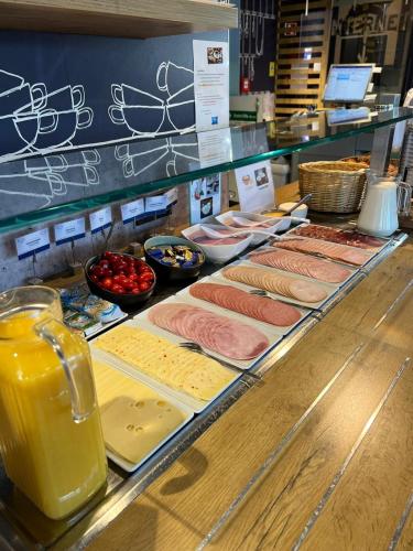 a buffet with meat and other food items on display at ibis budget Muenchen Putzbrunn in Putzbrunn