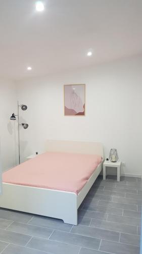 a white bedroom with a bed with a pink mattress at gite sous l'olivier in Marseille