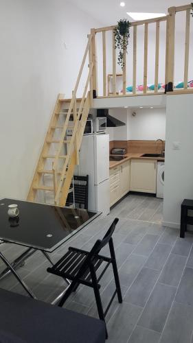 une cuisine avec un escalier et une table dans une pièce dans l'établissement gite sous l'olivier, à Marseille