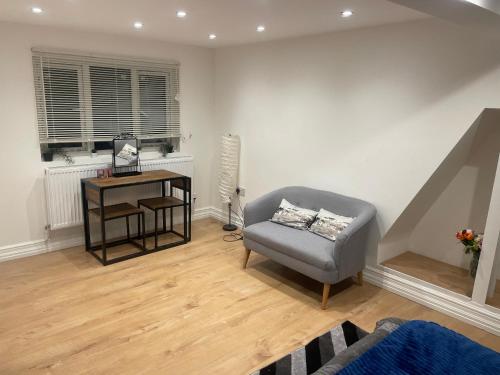 a living room with a chair and a desk at Spacious loft space with private en-suite bathroom in London