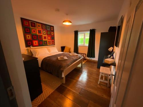 1 dormitorio con cama, escritorio y ventana en Wild Wild West Holiday Cottages, en Castletownbere