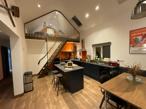 a kitchen and dining room with a spiral staircase at Wild Wild West Holiday Cottages in Castletownbere