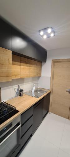 a kitchen with a sink and a stove top oven at Apartment SAND - Entry with PIN 0 - 24h, Luxury massage chair,Infrared sauna,FREE CANCELLATION 24 hours before Check In, Premium pillows and mattress in Slavonski Brod