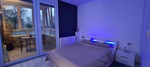 sypialnia z łóżkiem z niebieskimi lampkami w obiekcie Apartment SAND - Entry with PIN 0 - 24h, Luxury massage chair FREE CANCELLATION UNTIL 2 PM ON THE LAST DAY OF CHECK IN w mieście Slavonski Brod