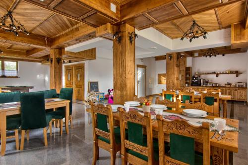 uma sala de jantar com uma mesa de madeira e cadeiras em Willa Mamcorka em Poronin