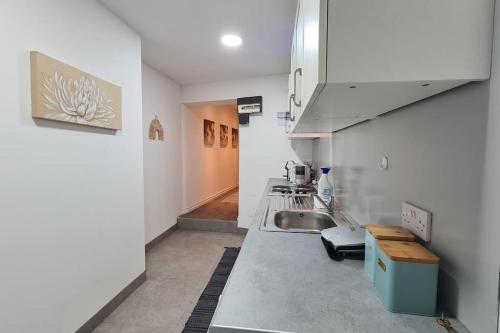 a kitchen with a sink and a counter top at Luxury 1 bedroom flat in the heart of Wood Green in London