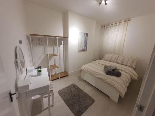 Luxury 1 bedroom flat in the heart of Wood Green في لندن: غرفة نوم بسرير ومكتب ومرآة