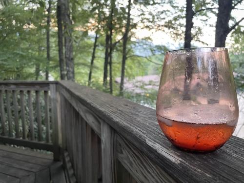 a wine glass sitting on a rail on a balcony at Mt Mitchell Cabin Rentals in Busick