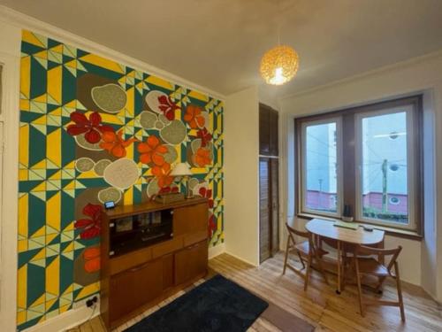 a living room with a table and a colorful wall at Lovely flat overlooking the Clyde in Gourock