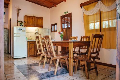 uma cozinha com uma mesa e cadeiras e um frigorífico em Estrella del Monte em Puerto Iguazú