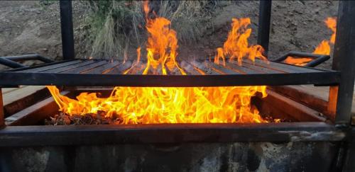 a grill with a bunch of fire in it at Cordillera Flora endógena Bosque Esclerófilo in San José de Maipo