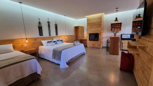 Cette chambre comprend deux lits et une télévision. dans l'établissement POUSADA JURERE DA CANASTRA, à Vargem Bonita