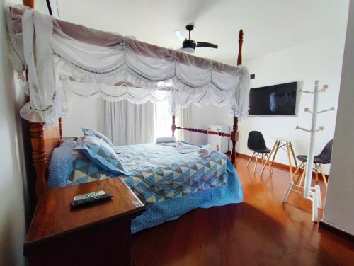 a bedroom with a canopy bed with a wooden floor at Marambaia Mar in Rio de Janeiro