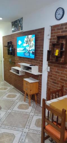 sala de estar con TV en una pared de ladrillo en Rowina Inn 1 en Tigre