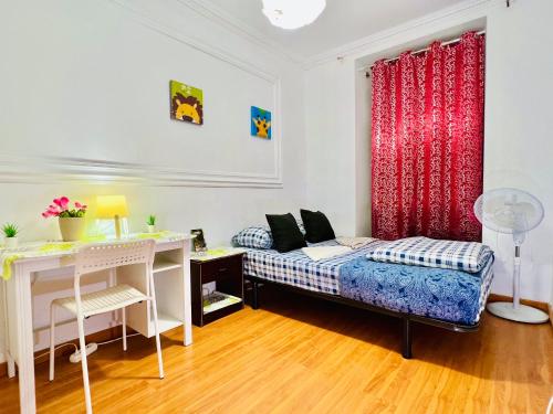 a bedroom with a bed and a desk and a table at Garden Guest House in Lisbon