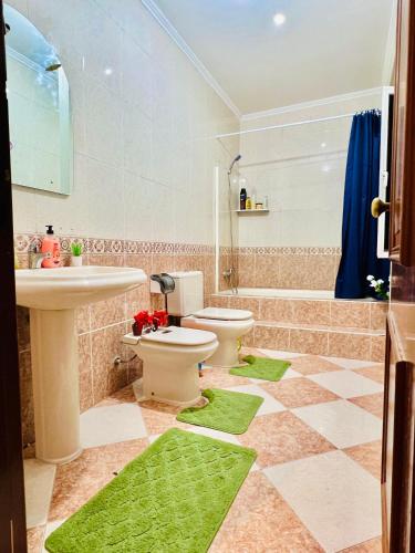 a bathroom with a toilet and a sink and a tub at Garden Guest House in Lisbon