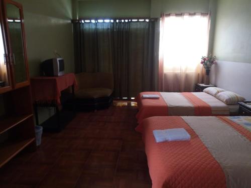a hotel room with two beds and a chair and a window at Stefany Hospedaje in Puerto Ayora