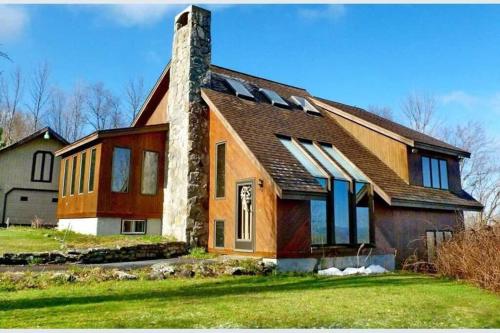 uma casa grande com uma chaminé em cima em Beautiful White Mountain Cottage with Hot Tub em Jefferson
