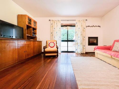 a living room with a couch and a tv at Refúgio do Vidoeiro in Geres