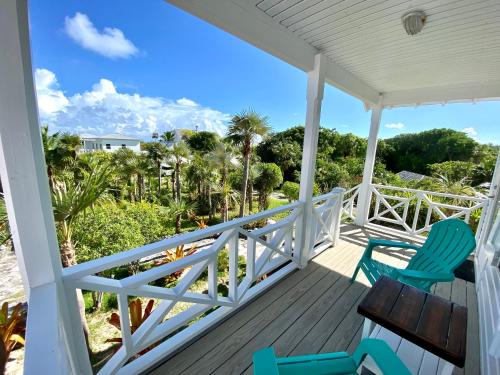 a porch with two chairs and a view of the beach at Eleuthera Retreat - Villa & Cottages on pink sand beachfront in North Palmetto Point