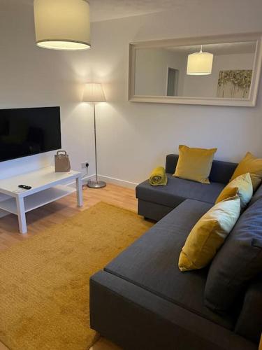 a living room with a couch and a tv at Glenbervie - Beautifully refurbished, self-contained apartment in Fife