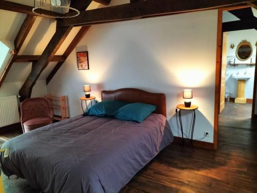 una camera da letto con un grande letto con due lampade su due tavoli di Longère Bretagne a Réminiac