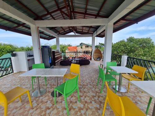 a patio with tables and chairs and a grill at Alona's Traditional Filipino Home near 100 Islands Wharf in Alaminos