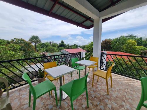 a patio with tables and chairs on a balcony at Alona's Traditional Filipino Home near 100 Islands Wharf in Alaminos