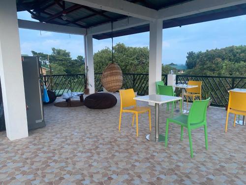 a patio with yellow and green chairs and tables at Traditional Filipino Home near 100 Islands Wharf in Alaminos