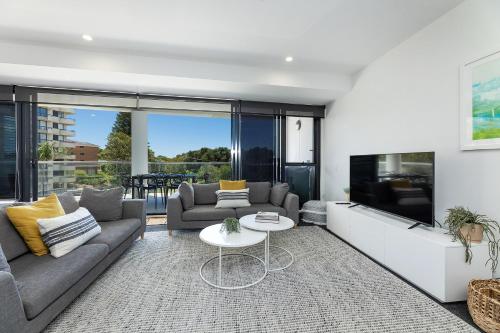 a living room with a couch and a table at The Cove 303 in Forster