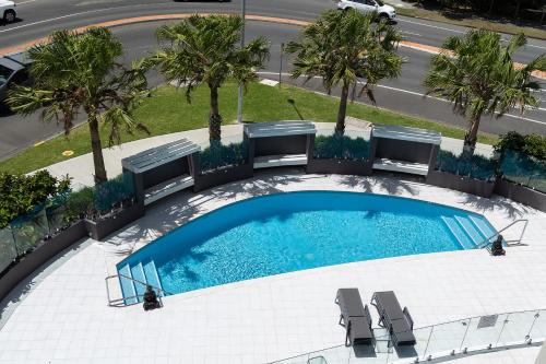 an overhead view of a swimming pool with chairs and palm trees at The Cove 303 in Forster