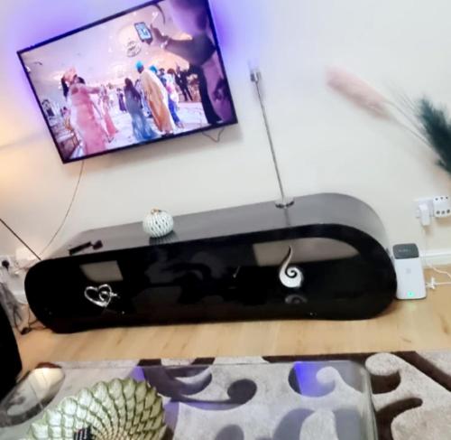 a computer desk with a monitor and a keyboard at 2 Bedroom Apartment - Greater London in Dagenham