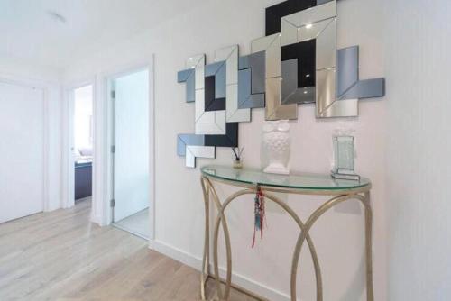 a room with a glass table and a mirror at Room with private bathroom in a modern two bedroom two bathroom flat in London