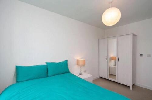 1 dormitorio con cama verde y armario blanco en Room with private bathroom in a modern two bedroom two bathroom flat en Londres